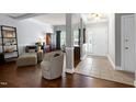 Open-concept living room with hardwood floors, elegant columns, and a welcoming foyer, perfect for entertaining and relaxation at 9508 Vira Dr, Raleigh, NC 27617