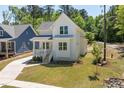 Stylish white farmhouse with manicured lawn, gray roof, and adjacent blue house at 1013 Forrestal Pl, Durham, NC 27707