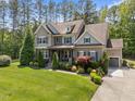 Well-manicured lawn surrounds this home with detailed architectural features and an attached garage at 1037 Lila Ln, Raleigh, NC 27614