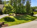 Lush front lawn and trees provide a serene setting and enhance curb appeal at 1037 Lila Ln, Raleigh, NC 27614