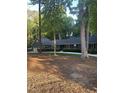 Home exterior showcasing a well-manicured lawn and mature trees at 10505 Winding Wood Trail Trl, Raleigh, NC 27613