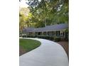 Inviting home exterior featuring lush greenery and a curved driveway at 10505 Winding Wood Trail Trl, Raleigh, NC 27613