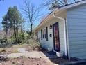 Side view of a light blue home with a front door, black shutters, and landscaped yard at 106 Eugene St, Carrboro, NC 27510