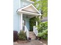 Inviting front porch with lush greenery and a decorative front door at 117 Idlewild Ave, Raleigh, NC 27601