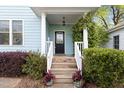 Inviting front porch with lush greenery and a decorative front door at 117 Idlewild Ave, Raleigh, NC 27601