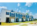 New construction townhomes showcase a blend of white vinyl, brick, and blue siding with pristine lawns and paved walkways at 117 N Chubb Rdg, Wilson's Mills, NC 27520