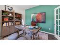 Stylish home office featuring a bold accent wall, wooden desk, shelving, and cozy seating at 1205 Pavo Path, Wendell, NC 27591