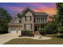 Charming brick two-story home featuring a two-car garage and inviting front yard at 1221 Tartarian Trl, Apex, NC 27502