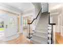 Bright foyer with hardwood floors and staircase, complemented by elegant trim at 1221 Tartarian Trl, Apex, NC 27502
