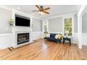 Cozy living room with a marble fireplace, hardwood floors, and natural light at 1221 Tartarian Trl, Apex, NC 27502
