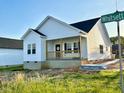 Lovely home with white siding and a welcoming front porch with a wooden railing at 1303 Whitsett St, Burlington, NC 27217