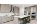 Modern kitchen with stainless steel appliances, quartz countertops, and bar stool seating at 136 Fairport Ln, Apex, NC 27539