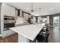 Modern kitchen featuring a large island with white countertop, stainless steel appliances, and pendant lighting at 138 North White St # 200, Wake Forest, NC 27587