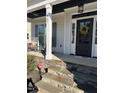 Inviting front porch with rocking chairs and stone accents leading to the entry at 145 Plantation Dr, Youngsville, NC 27596