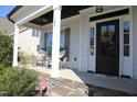 Charming front porch featuring rocking chairs, stone accents, and a welcoming front door at 145 Plantation Dr, Youngsville, NC 27596