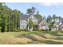Beautifully landscaped two-story home with stone and siding, surrounded by mature trees at 1520 Banks Brooke Dr, Raleigh, NC 27603