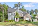 Charming two-story home with stone and siding, surrounded by mature trees and a manicured lawn at 1520 Banks Brooke Dr, Raleigh, NC 27603