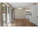 Open dining area with hardwood floors, large windows, and views of the kitchen at 1782 Quail Ridge Rd, Raleigh, NC 27609