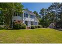 Beautifully landscaped two-story home with lush green lawn and mature trees on a sunny day at 2 Great Oak Ct, Durham, NC 27713