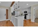 Charming kitchen features an island, white cabinets, modern appliances, and hardwood flooring at 2006 Woodstone Dr, Archer Lodge, NC 27527