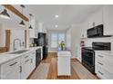 Bright kitchen features white cabinets, modern appliances, a large sink, and hardwood flooring at 2006 Woodstone Dr, Archer Lodge, NC 27527