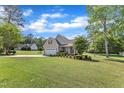 Wide shot of the home, revealing the spacious lawn, mature trees, and the overall neighborhood aesthetic at 202 Reeder Branch Dr, Clayton, NC 27520
