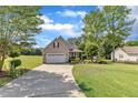 A cozy single-Gathering home with a two-car garage, manicured lawn, and plenty of surrounding trees at 202 Reeder Branch Dr, Clayton, NC 27520