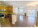 Open-concept living room and kitchen layout featuring hardwood floors, stainless steel appliances, and a fireplace at 204 Stockton Gorge Rd. Rd, Morrisville, NC 27560