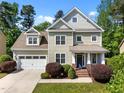 Charming two-story home with manicured lawn, lush landscaping, attached garage and welcoming front entrance at 208 Willowbend Ln, Hillsborough, NC 27278