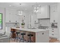 Gourmet kitchen with large island, sleek cabinetry, quartz counters, and geometric backsplash at 2104 Manuel St, Raleigh, NC 27612