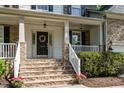 Inviting front porch featuring stone steps and decorative wreath on the front door at 215 Hopesworth Ct, Hillsborough, NC 27278
