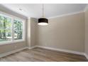 Bright bedroom with a large window, neutral walls, and a modern light fixture, offering a serene and inviting space at 2405 Pearces Rd, Zebulon, NC 27597