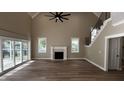 Open living room with hardwood floors, fireplace, high ceilings, and a staircase at 2405 Pearces Rd, Zebulon, NC 27597