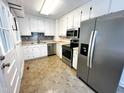 Well-lit kitchen with stainless steel appliances, white cabinets, and tile backsplash, perfect for home cooking at 2600 Newbold St, Raleigh, NC 27603