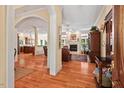 Open-concept living room with hardwood floors, fireplace, and ample natural light, flowing into the kitchen at 27 Woodgate Ct, Durham, NC 27713