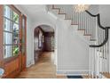 Welcoming foyer with hardwood floors, white staircase, and a view into a formal living space at 2704 Fairview Rd, Raleigh, NC 27608