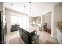 Open kitchen layout with an island, granite countertops, and stainless steel refrigerator at 2711 Laurelcherry St, Raleigh, NC 27612