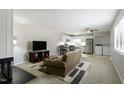 Open living space includes a ceiling fan and leads into a modern kitchen and laundry area at 294 Summerwalk Cir, Chapel Hill, NC 27517