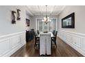 Bright dining room with coffered ceiling, hardwood floors, stylish chandelier, and elegant wainscoting at 3029 Mountain Hill Dr, Wake Forest, NC 27587