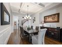 Dining room featuring hardwood floors, coffered ceiling, elegant wainscoting, and access to the staircase at 3029 Mountain Hill Dr, Wake Forest, NC 27587
