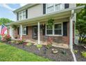 Inviting front porch adorned with flowers, rocking chairs, and an American flag waving in the breeze at 304 Cornelia Dr, Graham, NC 27253