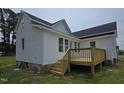 Newly built home featuring a wooden deck, complemented by pristine white siding and dark roofing for a modern aesthetic at 305 E Harnett St, Benson, NC 27504