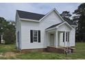 Charming two-story house features a quaint front porch, complemented by black shutters for a touch of elegance at 305 E Harnett St, Benson, NC 27504