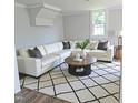 Bright living room features a white sectional sofa, modern round coffee table, and a stylish black and white rug at 305 E Harnett St, Benson, NC 27504