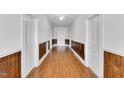 Long hallway with hardwood floors, white walls, and a ceiling fan at 310 Chicopee Rd, Benson, NC 27504