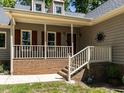 Close up of the front porch with red brick foundation, featuring a white railing and steps leading to the entrance at 312 Heidinger Dr, Cary, NC 27511