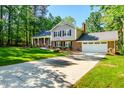 Charming brick and siding home featuring a long drive, an attached garage and a manicured front lawn at 3301 Manor Ridge Dr, Raleigh, NC 27603