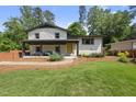 Inviting exterior showcasing a stone-accented home with a bright yellow door and lush green lawn at 3704 Swann St, Raleigh, NC 27612