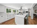 Bright, modern kitchen featuring white cabinetry, a large island, and stainless steel appliances at 3704 Swann St, Raleigh, NC 27612