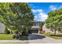 Inviting front exterior showcasing a well-maintained lawn, mature trees, and a gray two-story home with a two-car garage at 3801 Althorp Dr, Raleigh, NC 27616